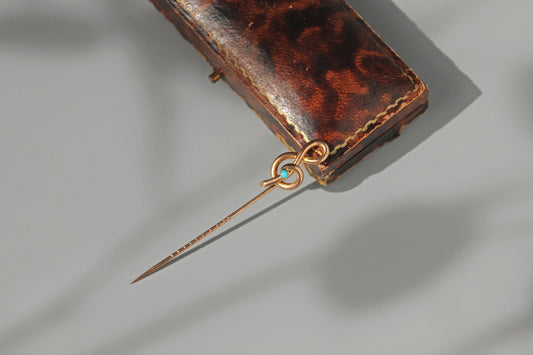 9ct gold edwardian antique musical pin with turquoise stone, displayed on antique jewellery box in the sunlight