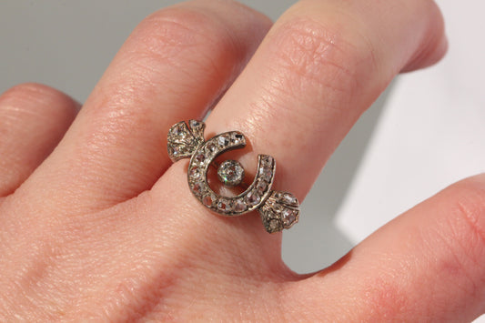 Antique diamond horseshoe ring worn on hand