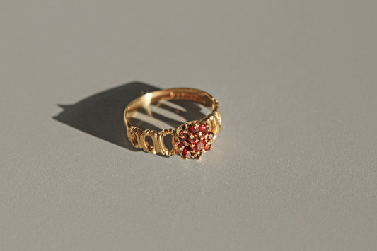 Close up of garnet daisy cluster ring with bark textured band