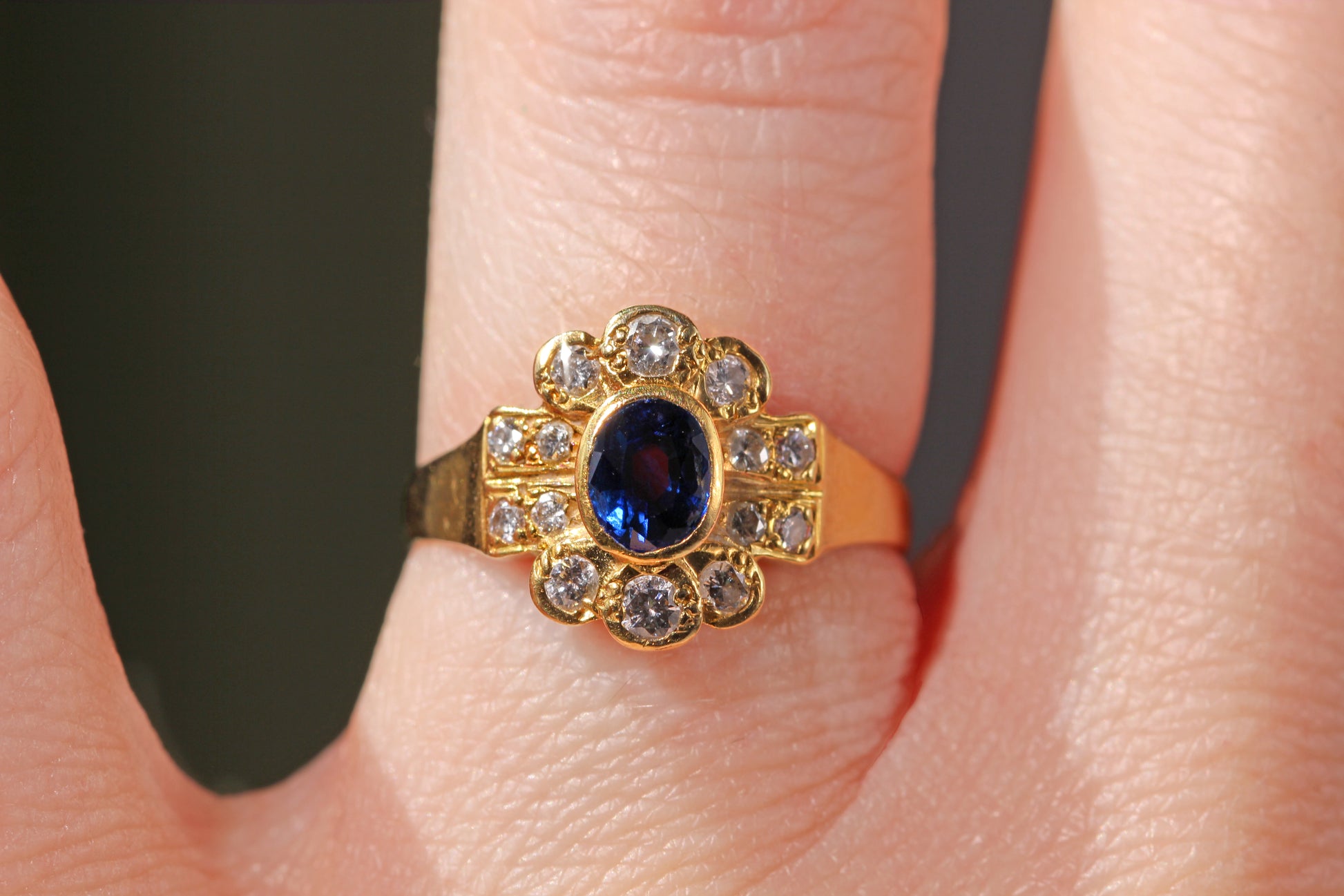 Vintage sapphire and diamond cluster ring on the finger 
