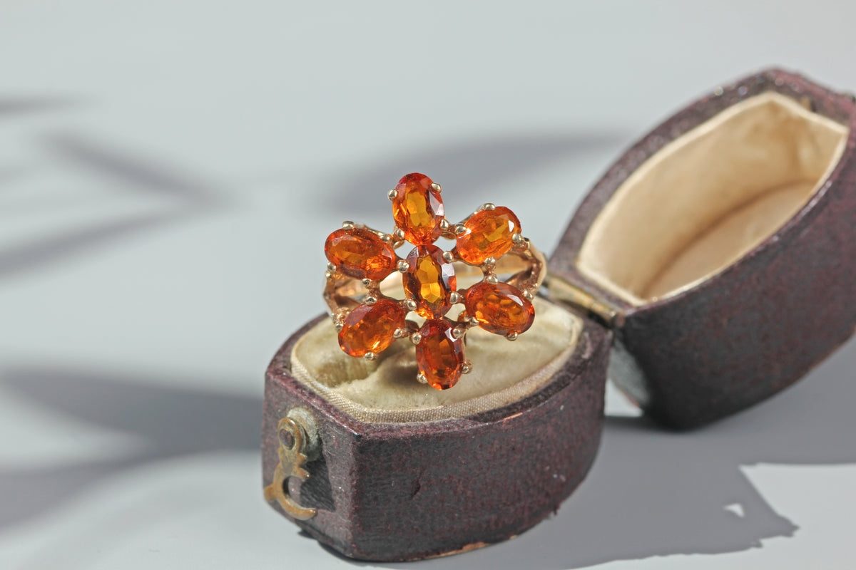 1970s orange topaz floral cluster ring in 9 carat gold displayed in an antique ring box
