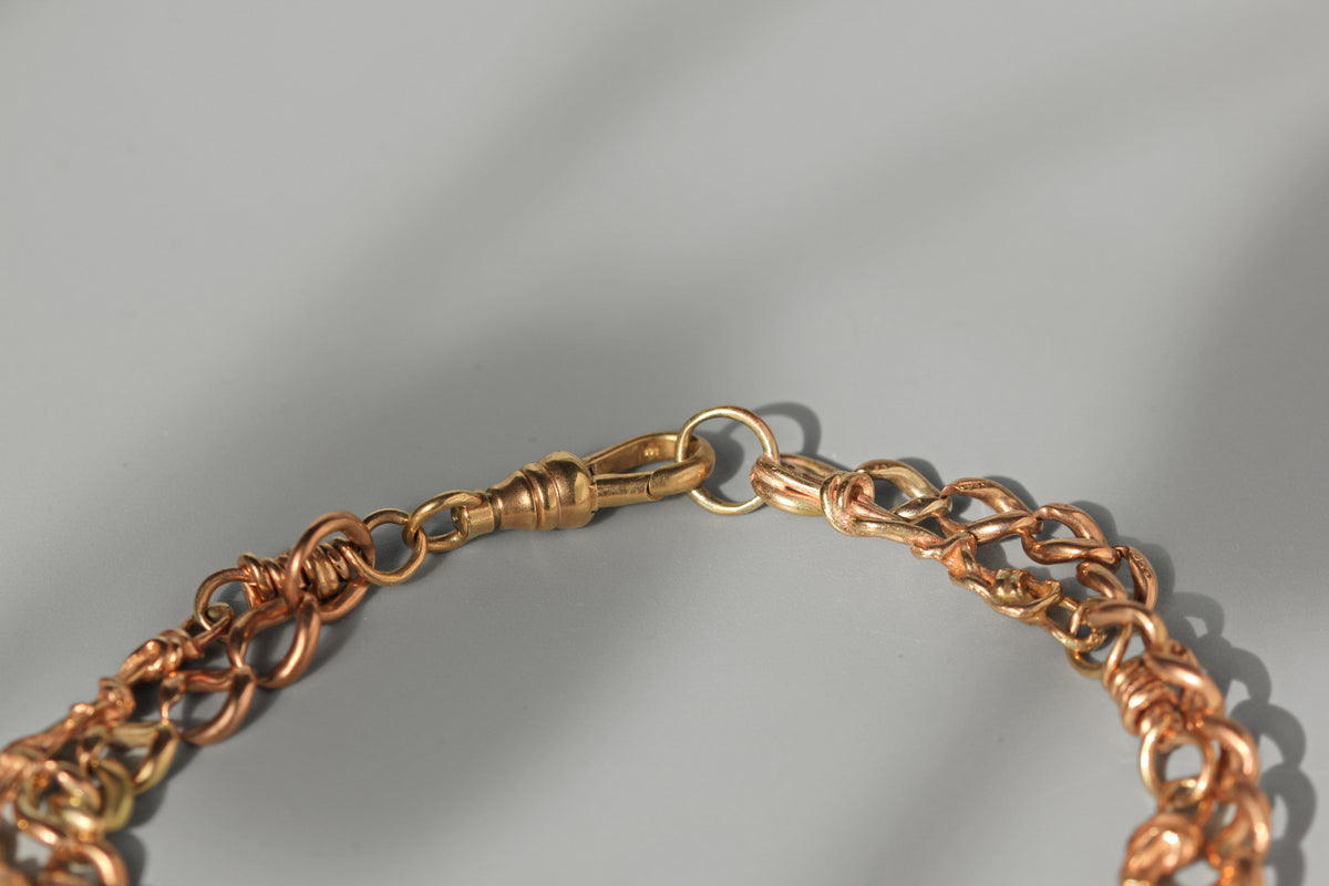 Close up of antique 9ct gold dog clip or lobster clasp on grey background