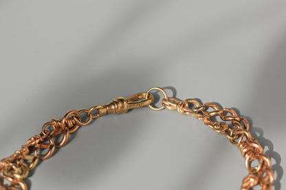 Close up of antique 9ct gold dog clip or lobster clasp on grey background