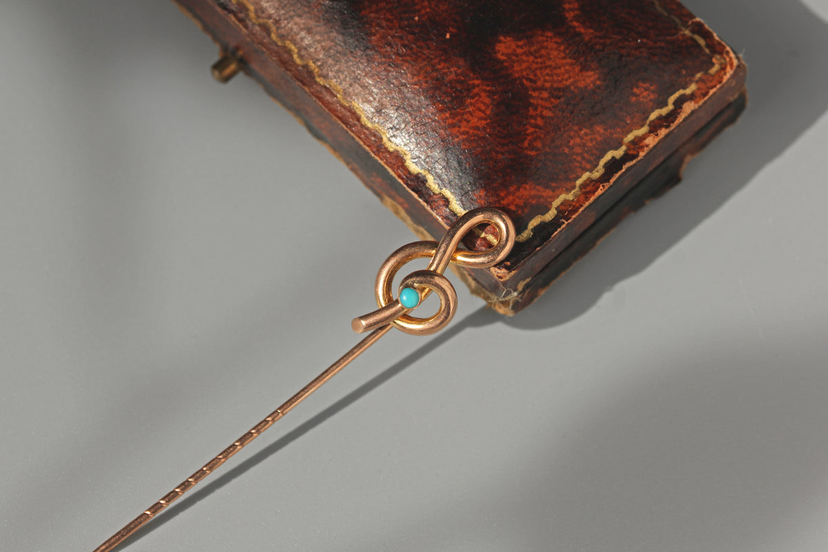 Unique treble clef pin crafted in 9ct gold with a turquoise cabochon 