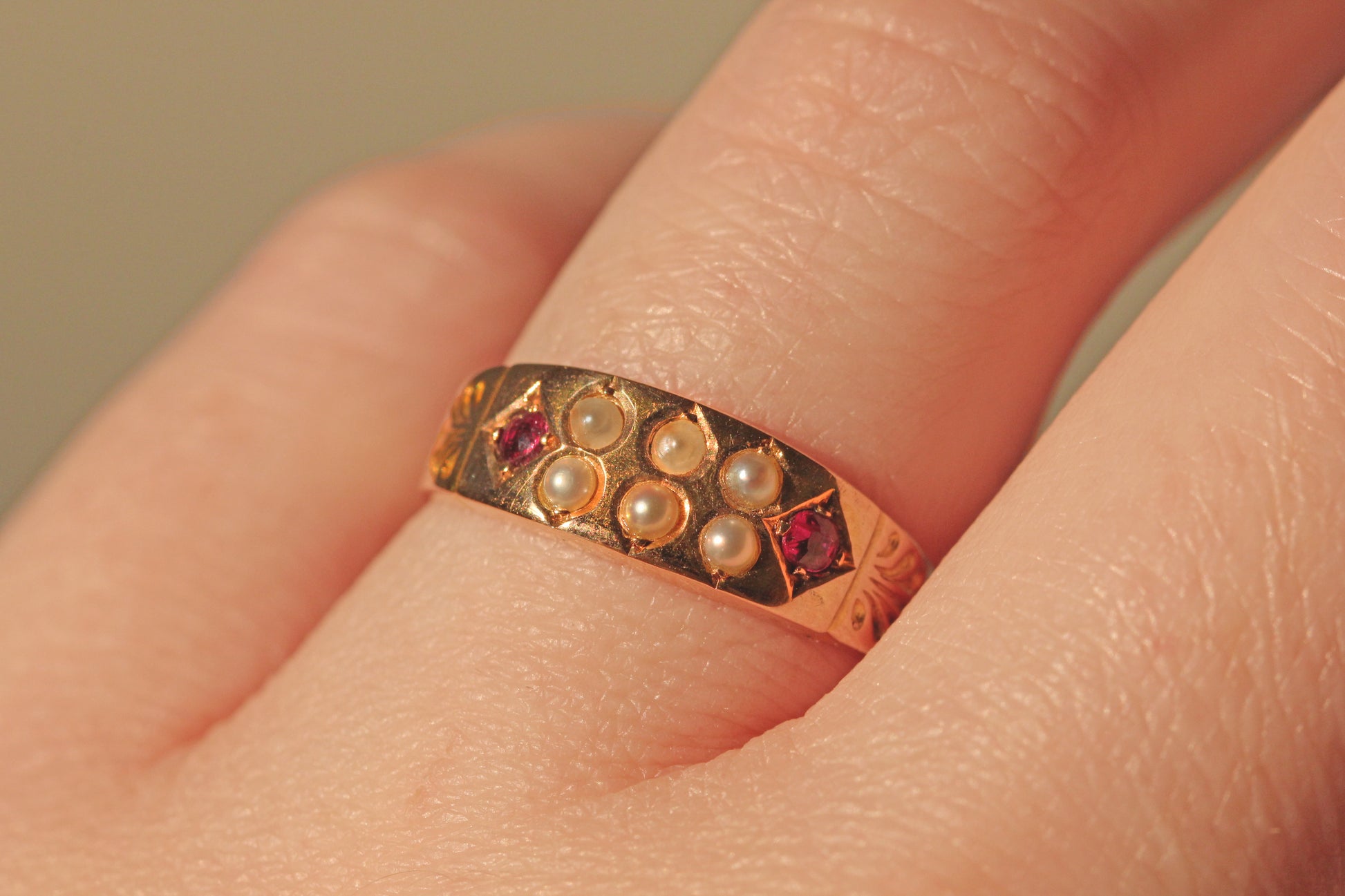 Victorian 15 carat gold ring with diamond shaped ruby bezels on finger