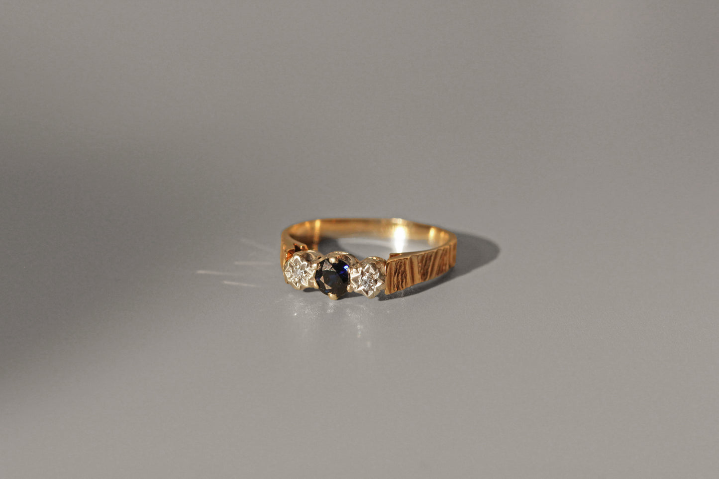 Mid century sapphire and diamond ring with star detailed bezels
