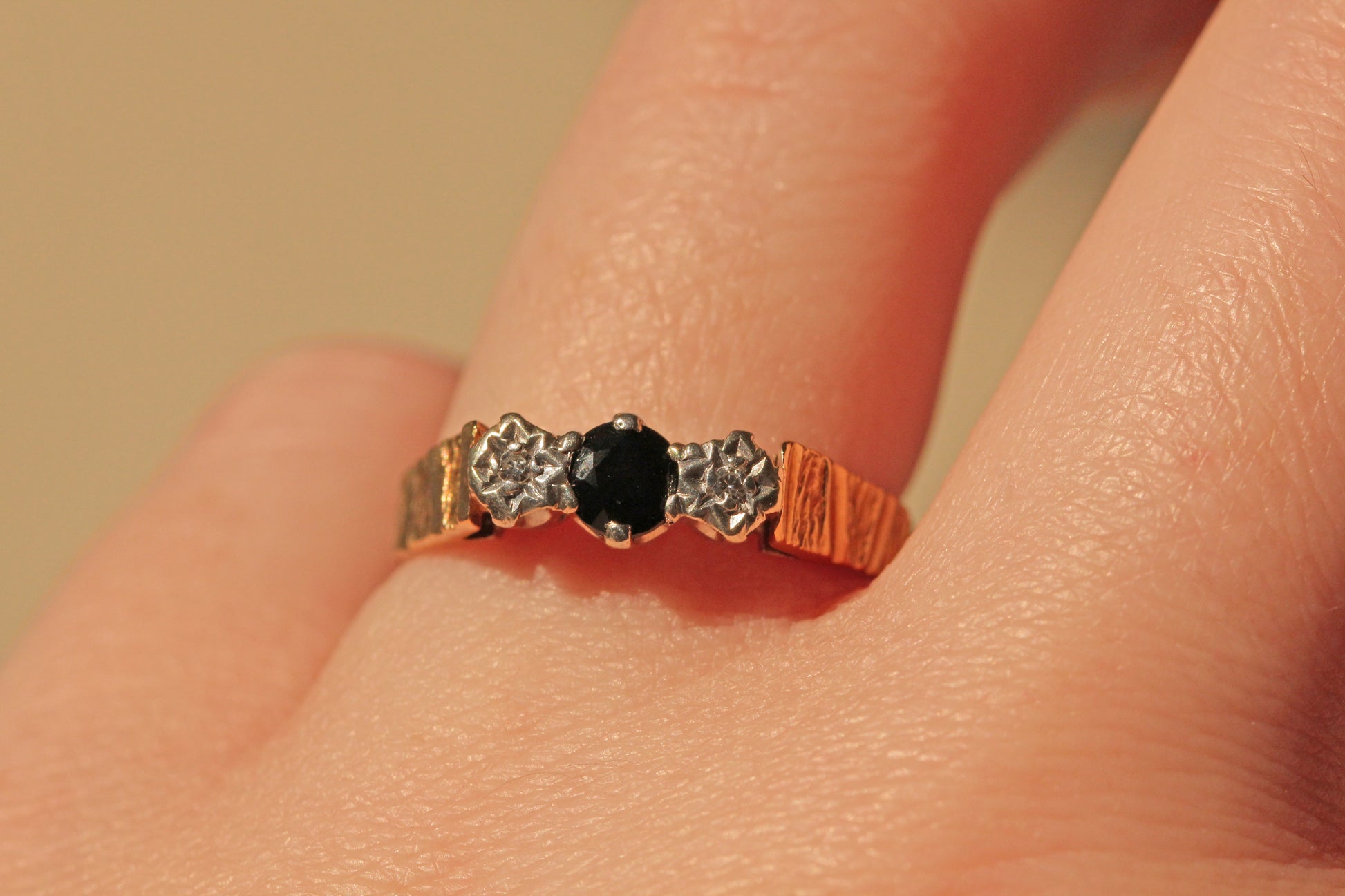 Vintage diamond and sapphire trilogy ring in 9 carat gold on finger