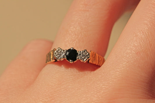 Vintage diamond and sapphire trilogy ring in 9 carat gold on finger