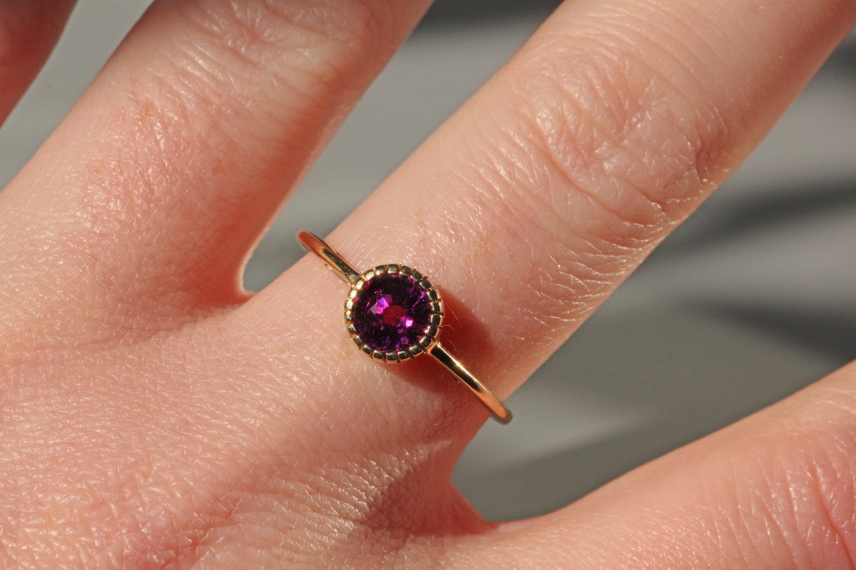Vintage purple garnet solitaire ring in 10ct gold on finger