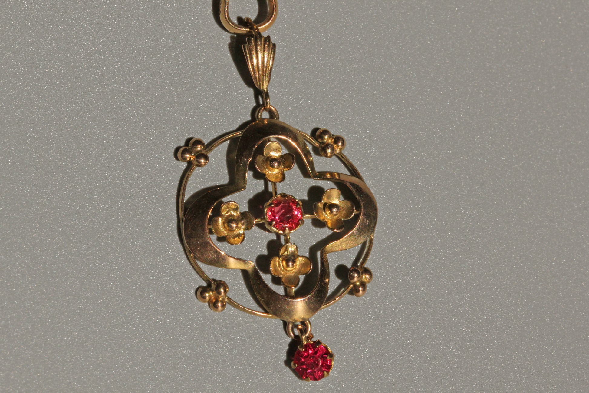 Close up of ruby paste pendant with forget-me-not floral motifs
