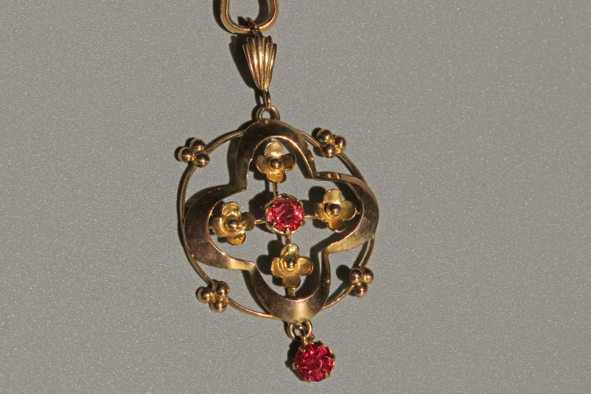 Close up of ruby paste pendant with forget-me-not floral motifs
