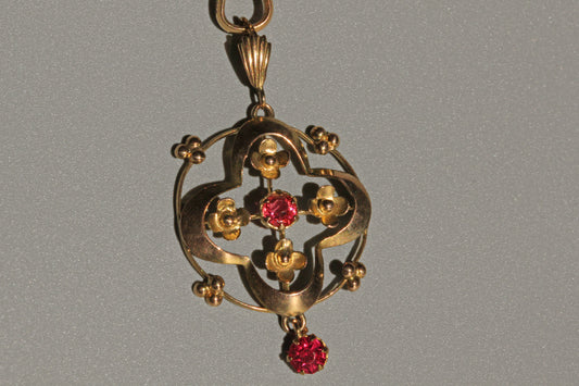 Close up of ruby paste pendant with forget-me-not floral motifs
