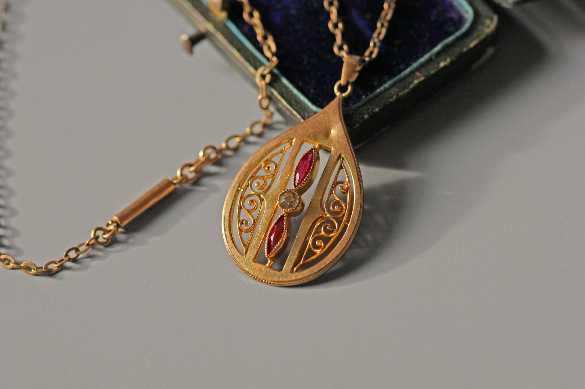 Close up of Art Nouveau pendant with pink paste stones and openwork
