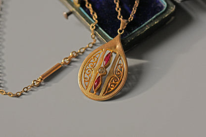 Close up of Art Nouveau pendant with pink paste stones and openwork
