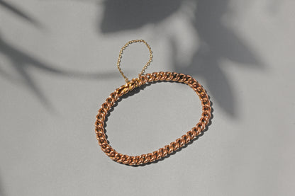 Close up of antique concealed clasp curb link bracelet with polished rounded links
