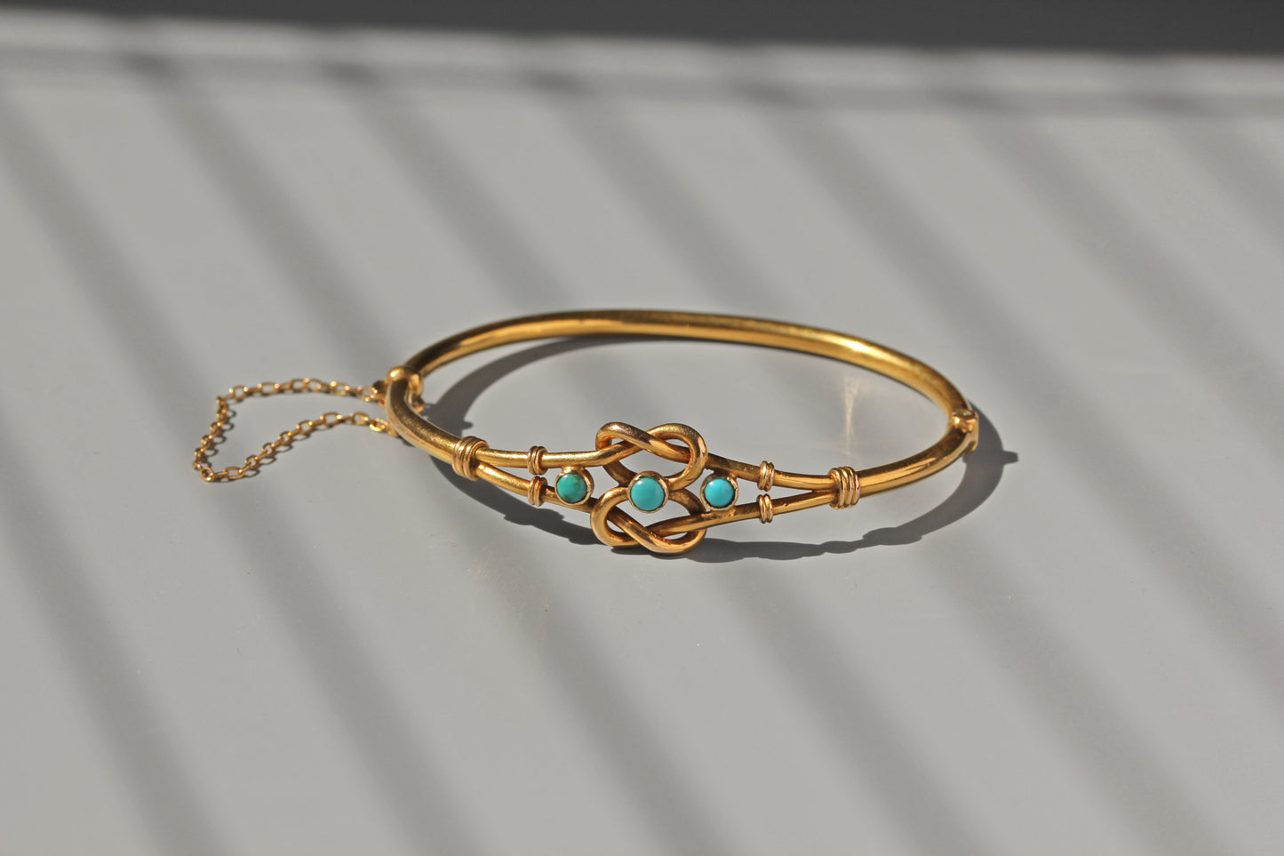 Antique gold bangle with turquoise and knot design
