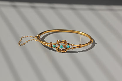 Antique gold bangle with turquoise and knot design
