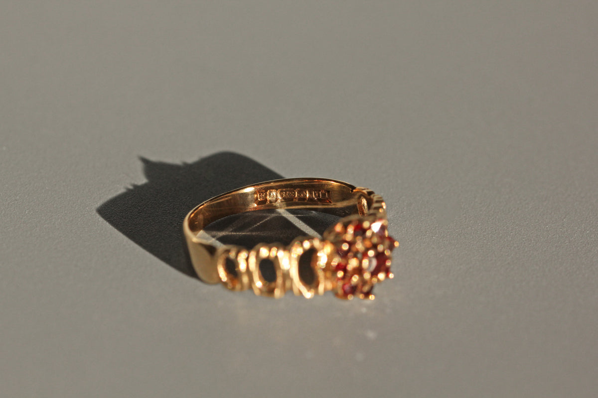 Vintage garnet flower cluster ring in 9 carat gold hallmarks close up