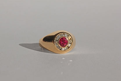 Chunky gold bombe ring with central ruby and diamond surround
