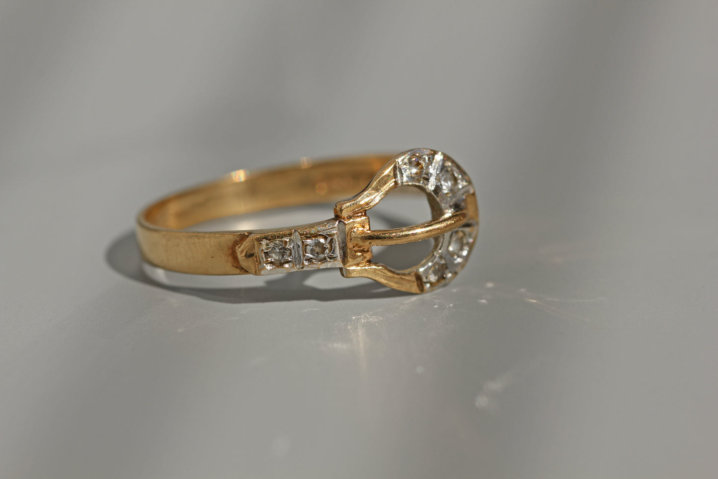 Gold belt buckle ring with diamond detail
