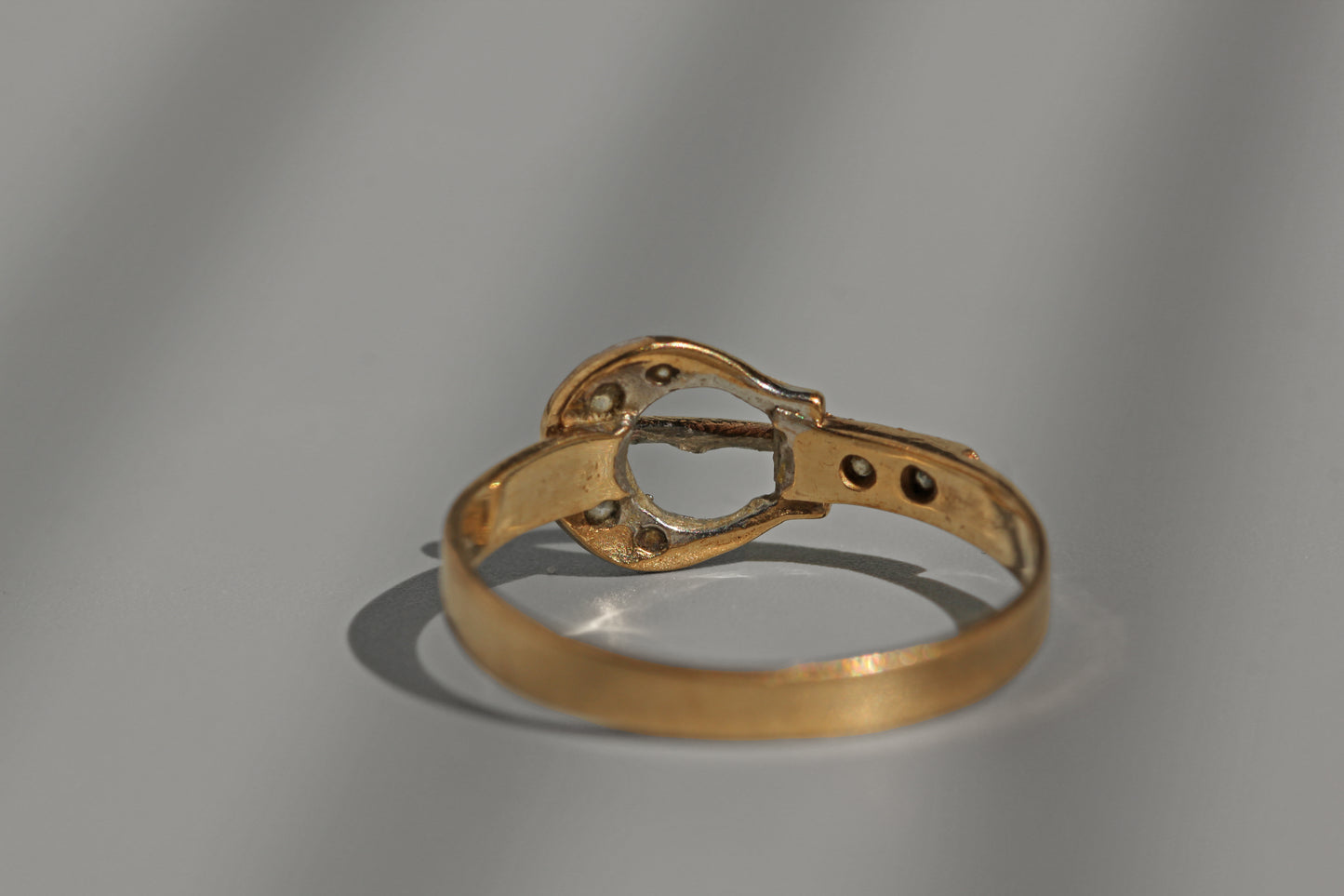 Close up vintage gold belt buckle ring with diamonds
