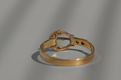 Close up vintage gold belt buckle ring with diamonds
