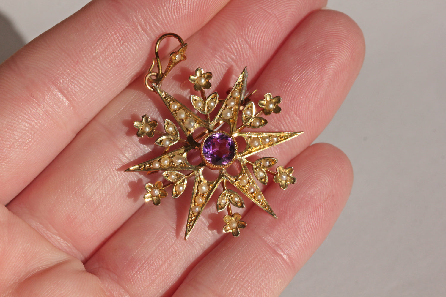 Close up of Victorian star pendant with central amethyst
