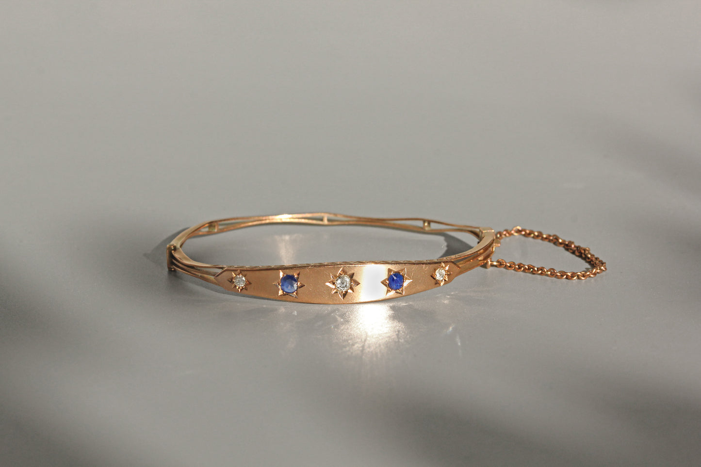 Antique hinged bangle with safety chain and oval shape
