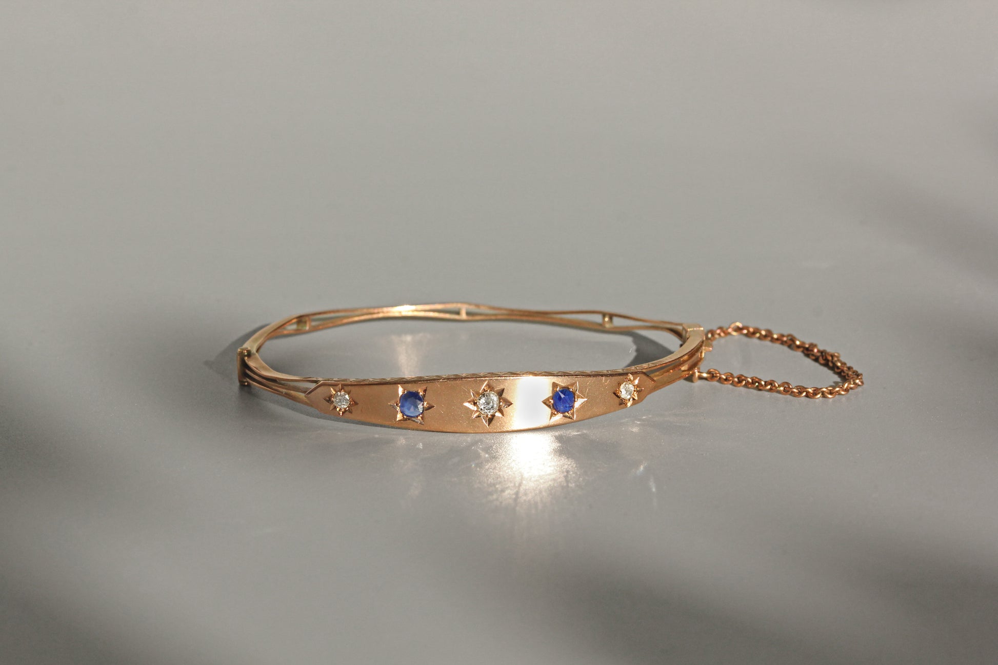 Antique hinged bangle with safety chain and oval shape
