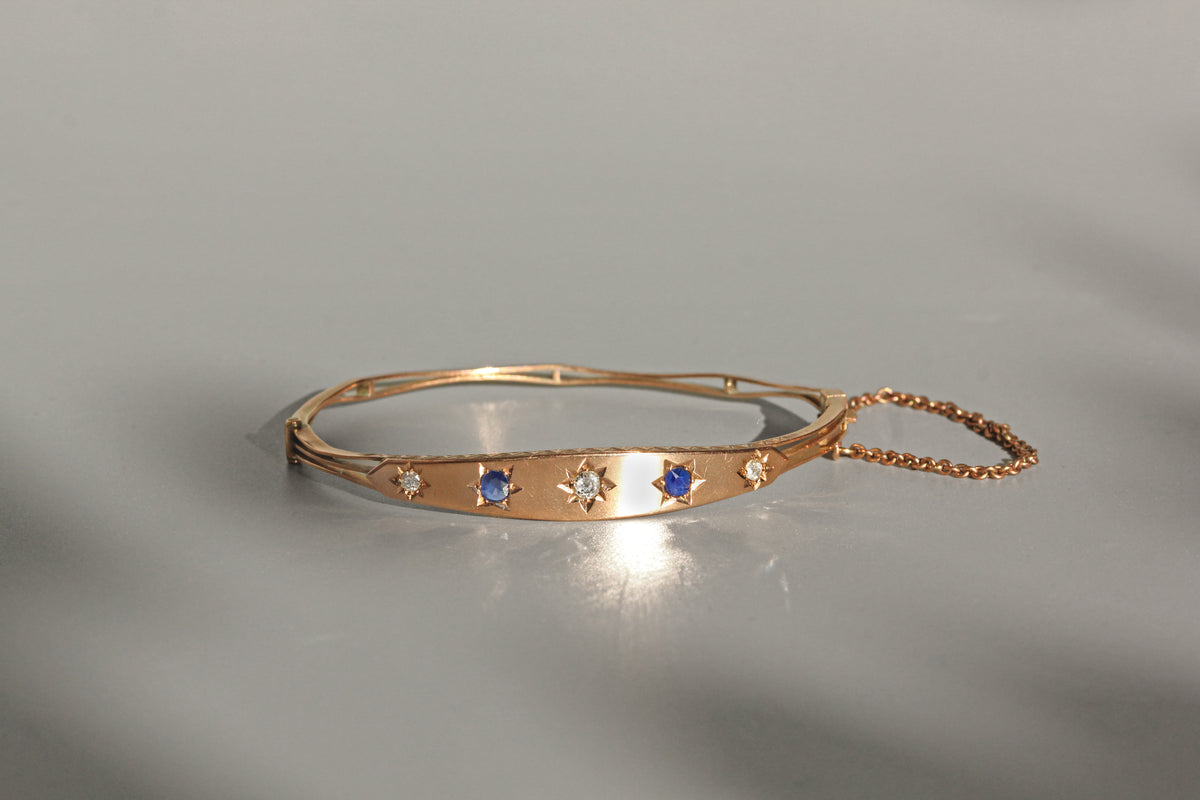 Antique hinged bangle with safety chain and oval shape
