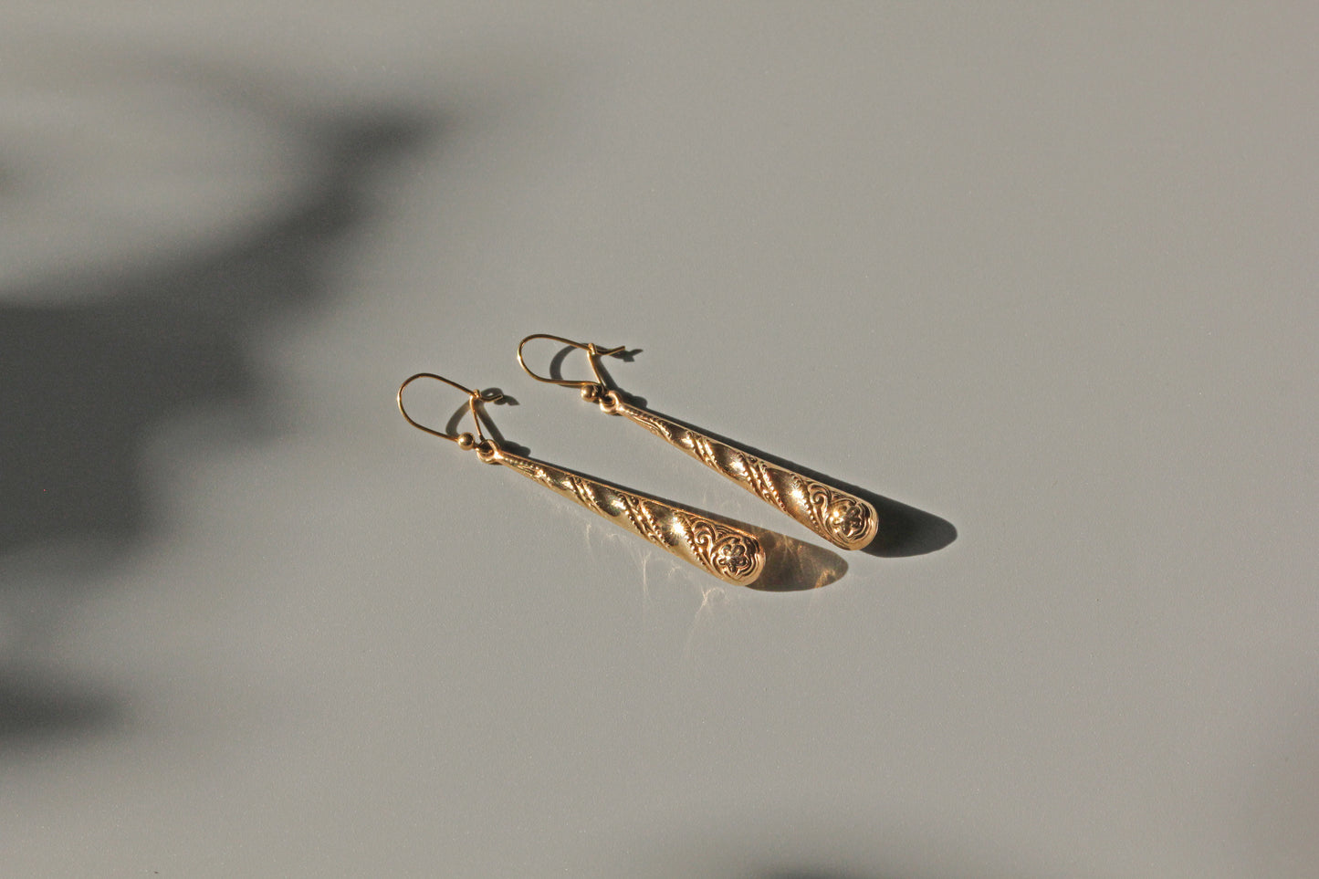 Vintage gold drop earrings with milgrain and swirl decoration
