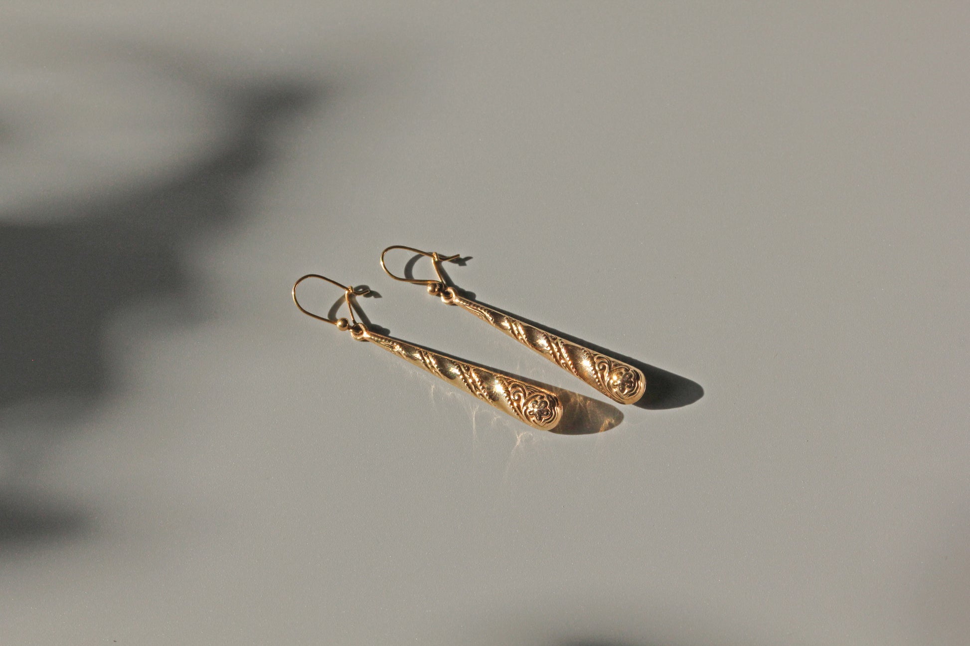 Vintage gold drop earrings with milgrain and swirl decoration
