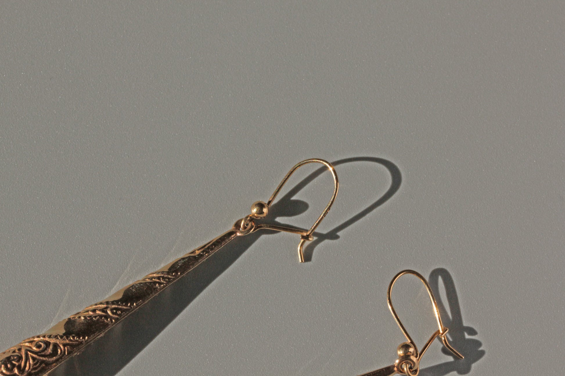Side view of vintage forget-me-not drop earrings in gold