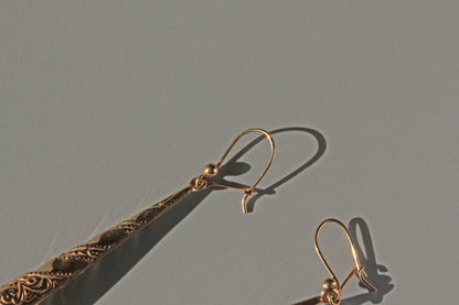 Side view of vintage forget-me-not drop earrings in gold