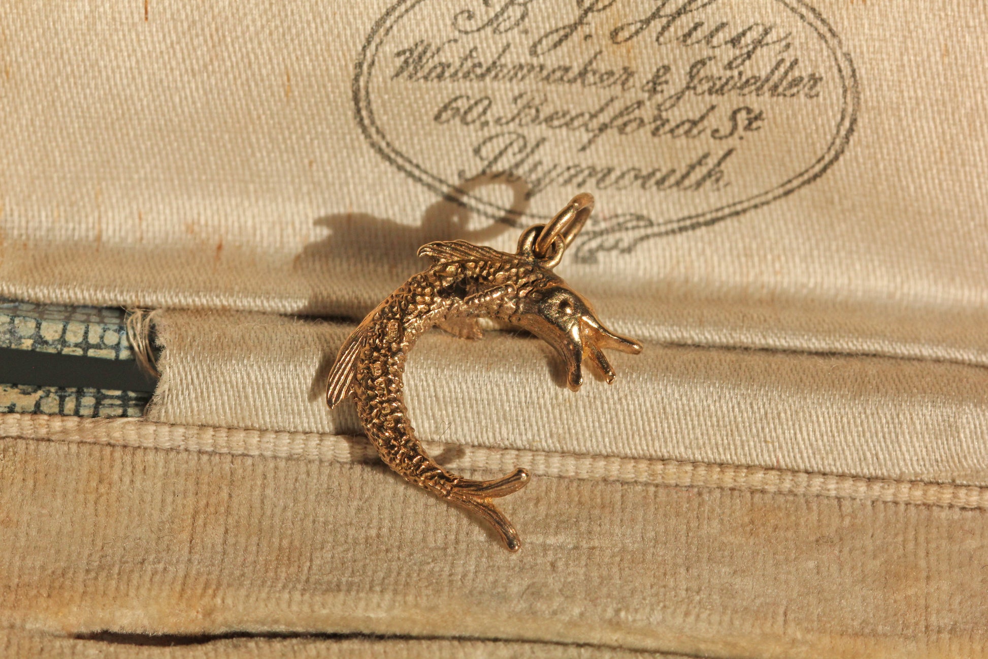 Close up of detailed fish charm with textured scales
