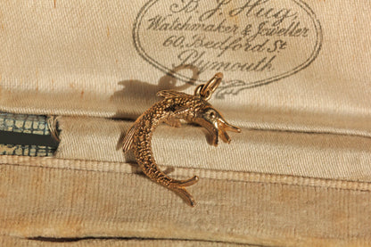 Close up of detailed fish charm with textured scales
