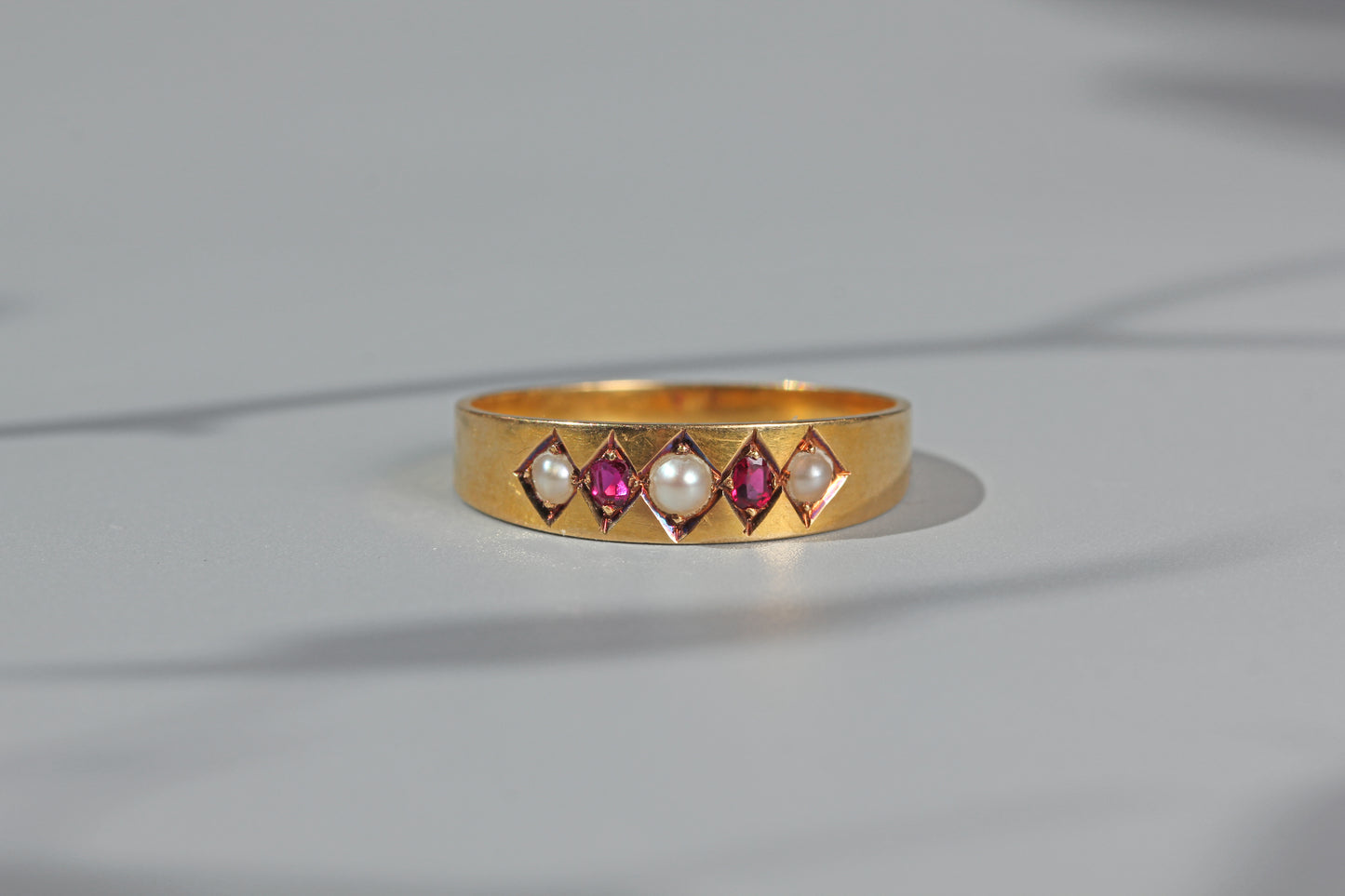 Antique ruby and pearl band ring, in 18 carat gold