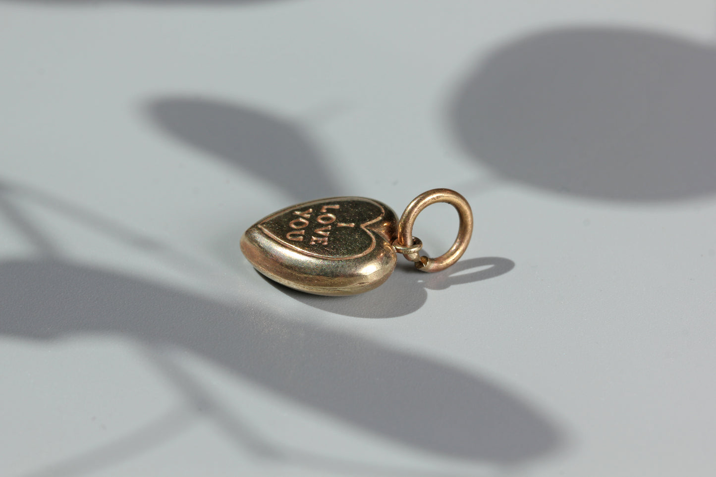 Vintage gold charm with engraved heart design
