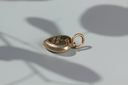 Vintage gold charm with engraved heart design

