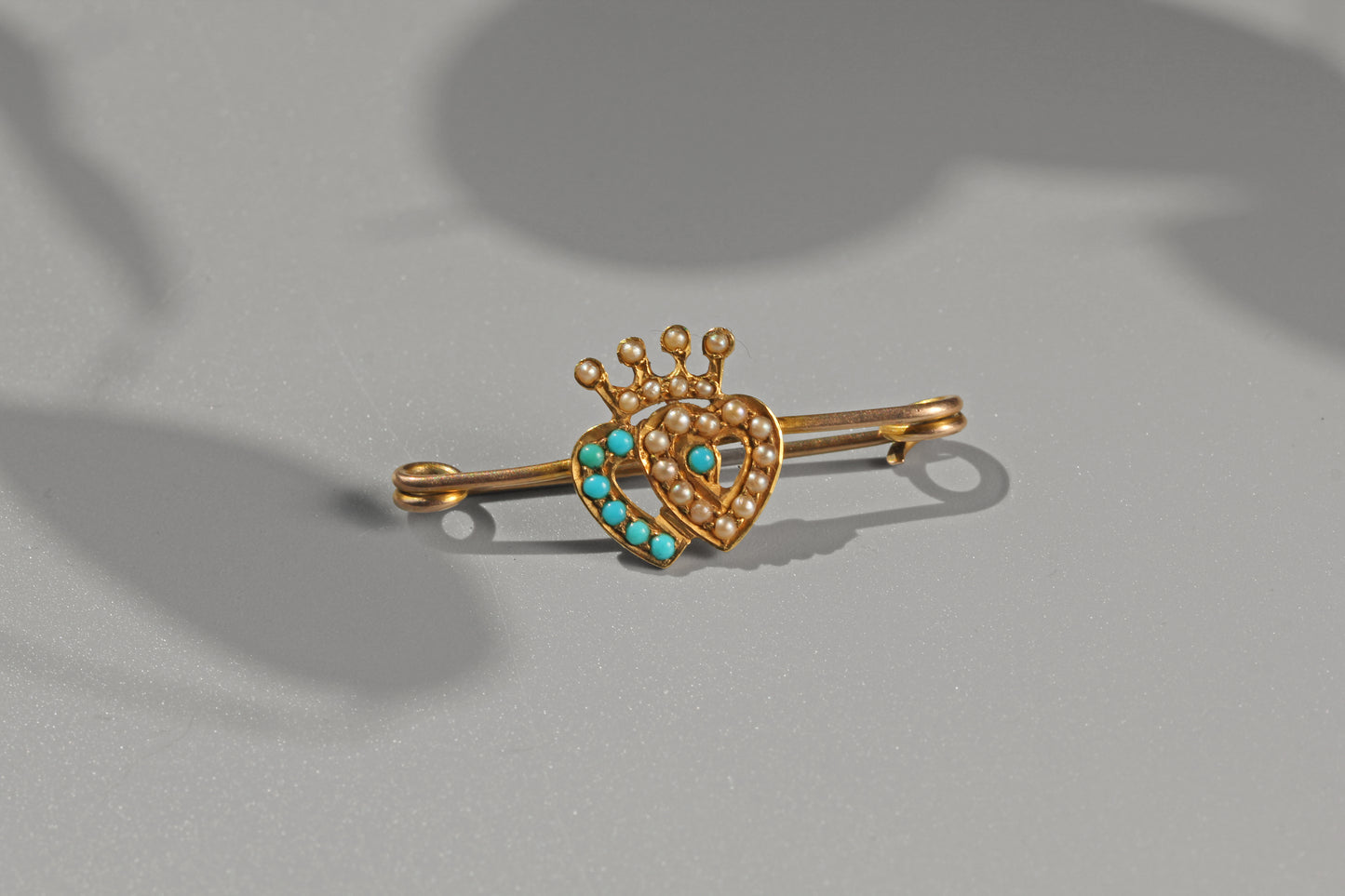 Victorian turquoise and pearl bar pin crafted in 15 carat gold with crowned double heart motif
