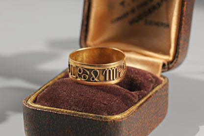 Vintage zodiac ring resting inside an antique velvet jewellery box

