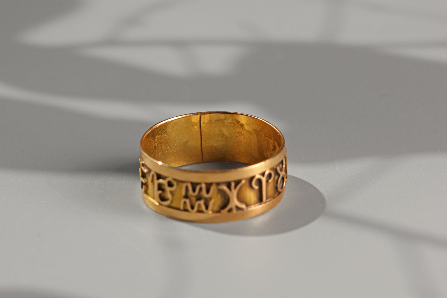 Openwork 18 carat gold horoscope ring with graphic symbol detailing
