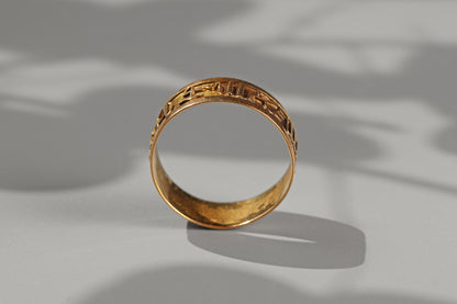 Vintage astrology themed gold band ring photographed in natural sunlight
