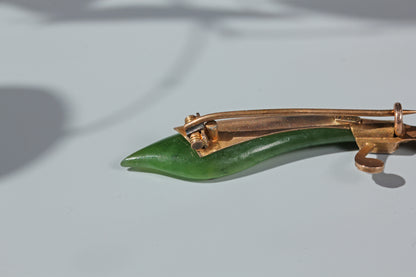 Detailed view of antique gold brooch clasp and nephrite jade blade
