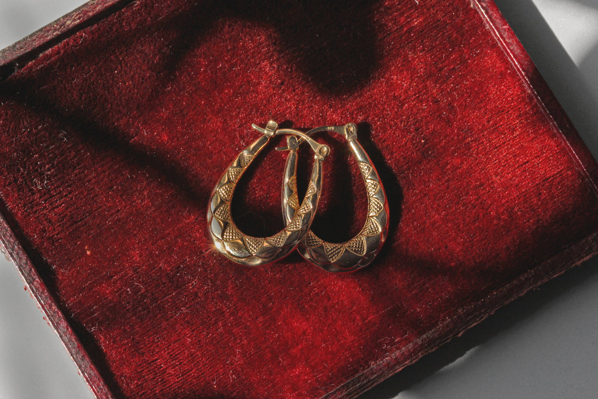 Vintage creole hoop earrings in 9 carat gold on red velvet jewellery box