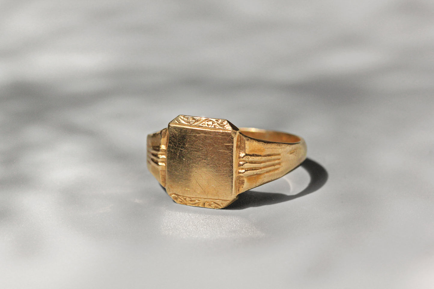 Close up of blank signet face with foliate scroll detail
