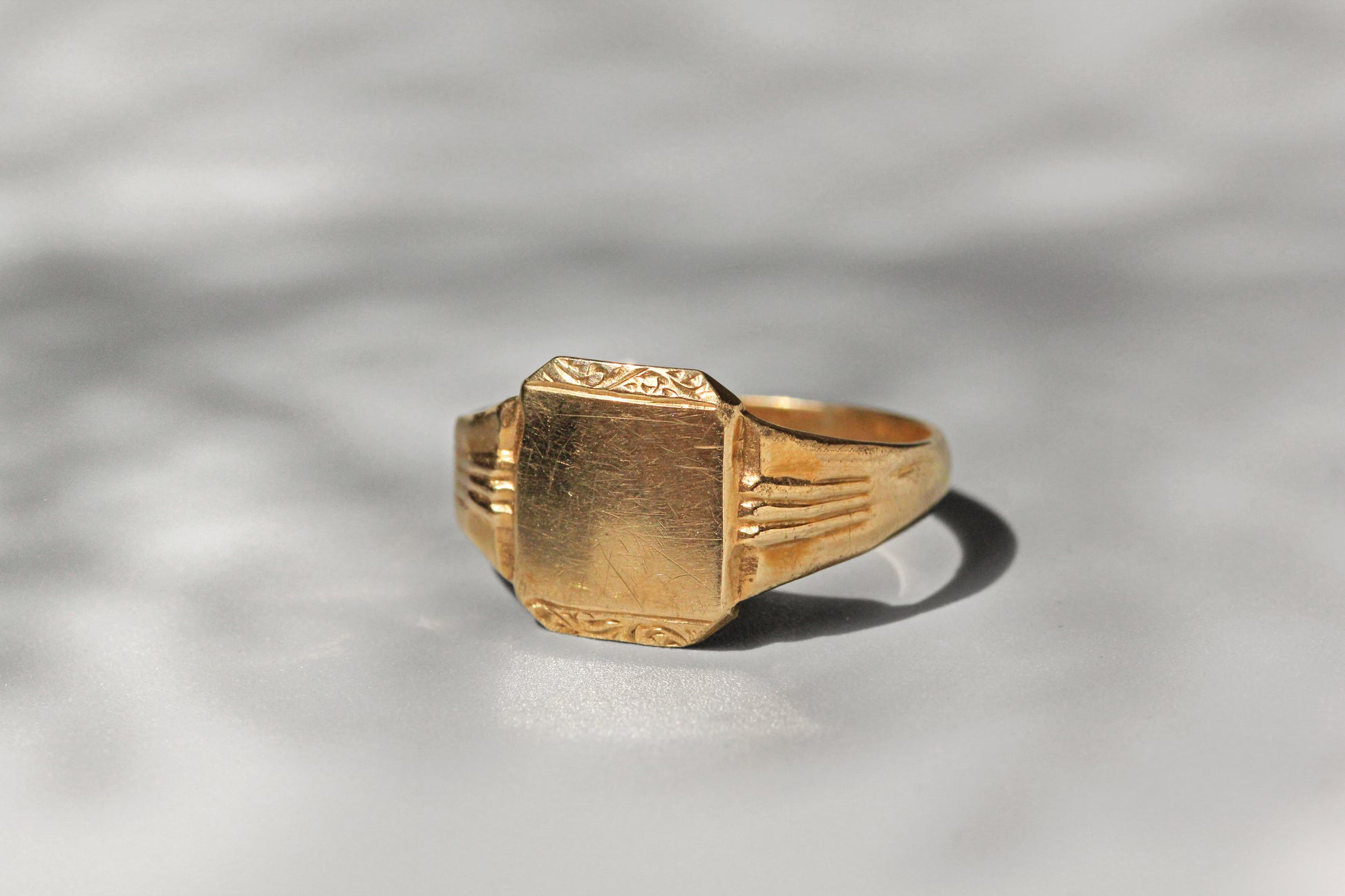 Close up of blank signet face with foliate scroll detail
