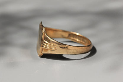 Side view of vintage gold signet ring with engraved shoulders