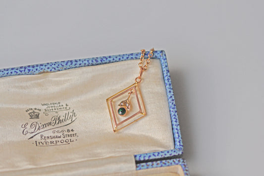 Close up of green tourmaline and seed pearl floral pendant
