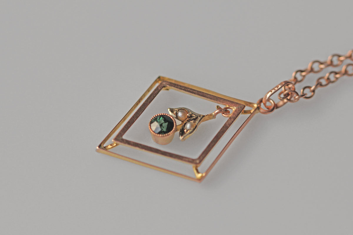 Antique gold pendant with green tourmaline and pearl detail
